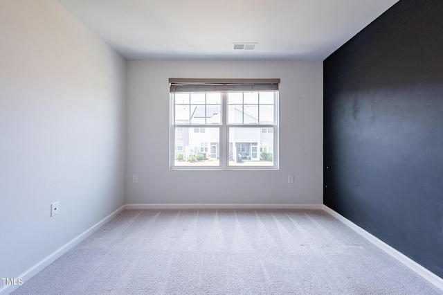 spare room with light carpet and baseboards