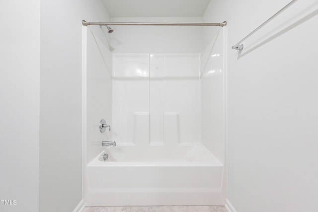 bathroom featuring washtub / shower combination and baseboards