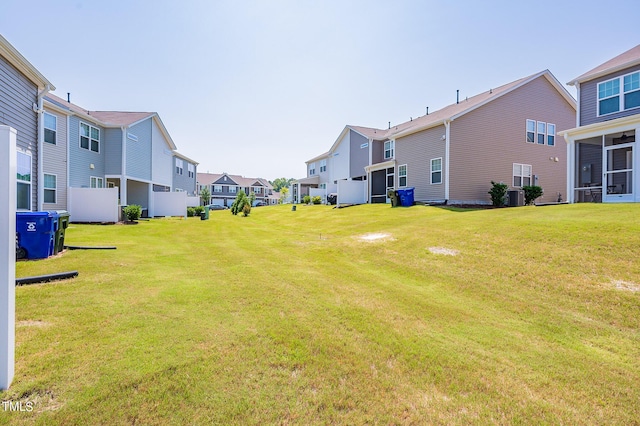 view of yard featuring a residential view and central AC unit