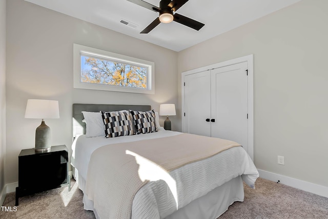 carpeted bedroom featuring ceiling fan and a closet