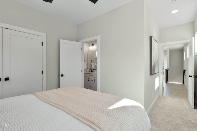 carpeted bedroom with connected bathroom and a closet