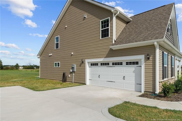 view of side of property featuring a yard and a garage