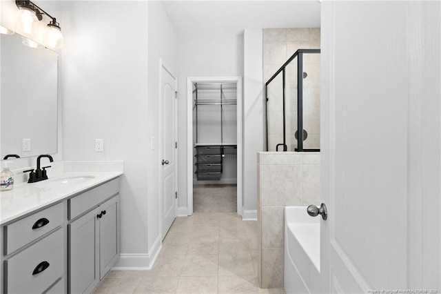 bathroom featuring walk in shower, vanity, and tile patterned flooring