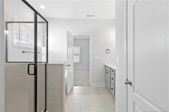 bathroom with an enclosed shower, vanity, and tile patterned floors