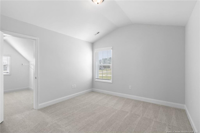 carpeted spare room with lofted ceiling