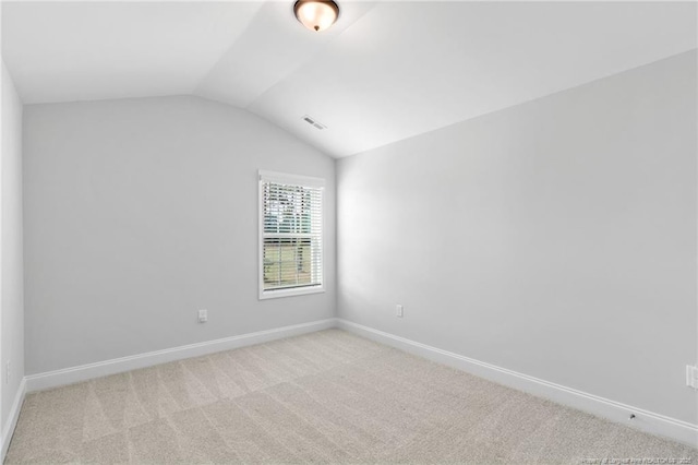 carpeted spare room with lofted ceiling