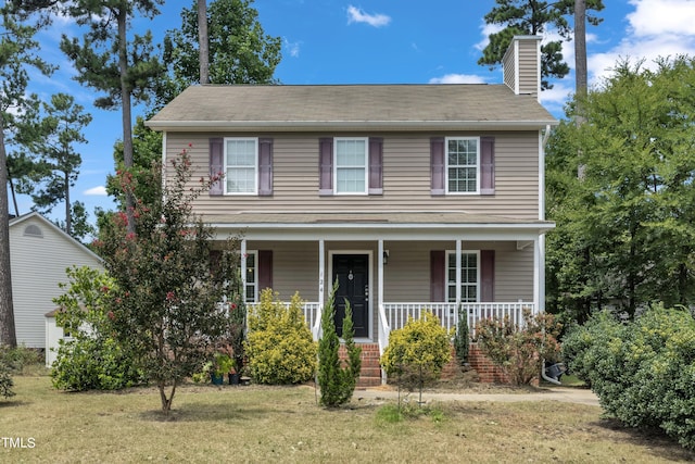 view of front of home with covered porch and a front yard