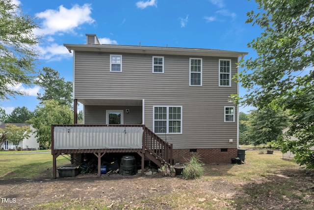 rear view of house featuring a lawn and a deck