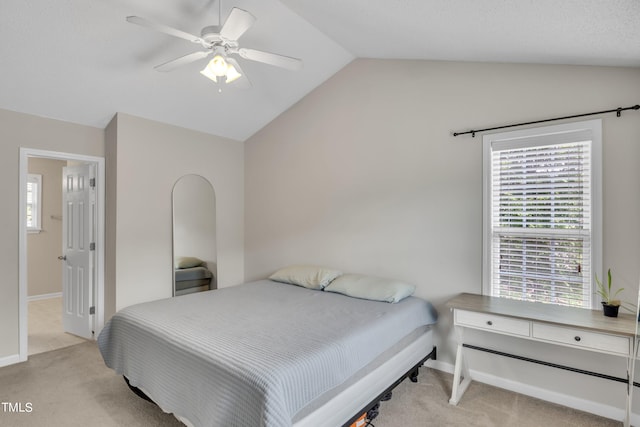 bedroom with lofted ceiling, ceiling fan, and light carpet