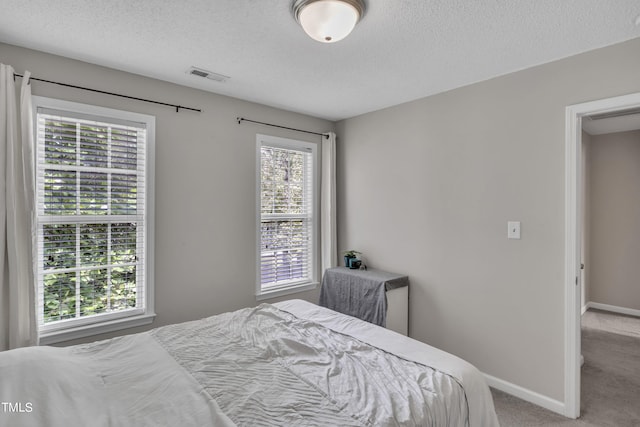 carpeted bedroom featuring a textured ceiling