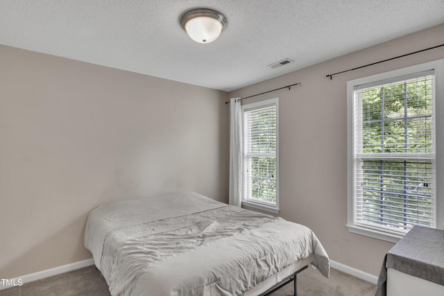 bedroom with carpet and a textured ceiling