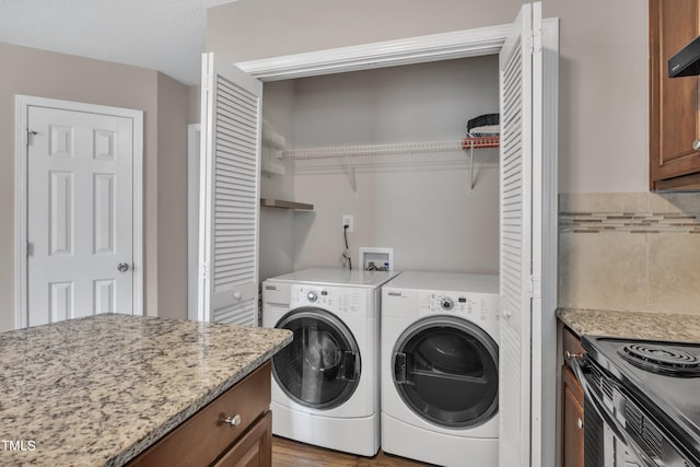 washroom with light wood-type flooring, a textured ceiling, and washing machine and dryer