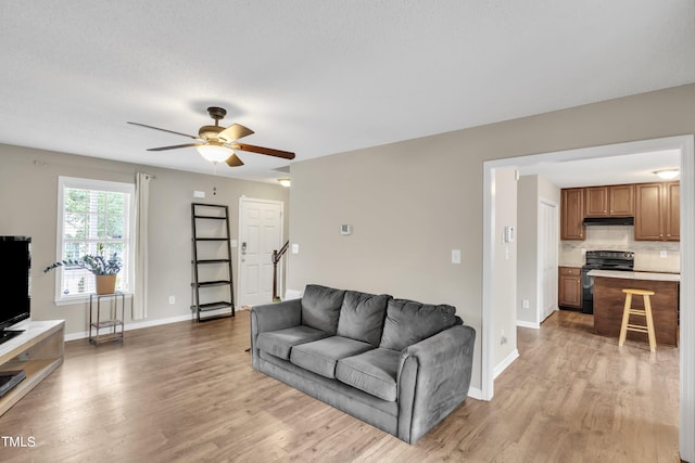 living room featuring a textured ceiling, ceiling fan, and hardwood / wood-style floors