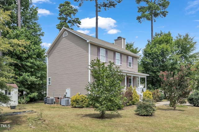 view of home's exterior with a yard, cooling unit, and covered porch