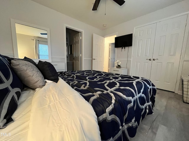 carpeted bedroom featuring a wainscoted wall, a closet, and ceiling fan