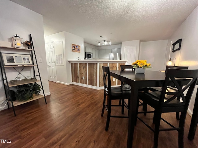 dining space featuring dark hardwood / wood-style floors and a textured ceiling