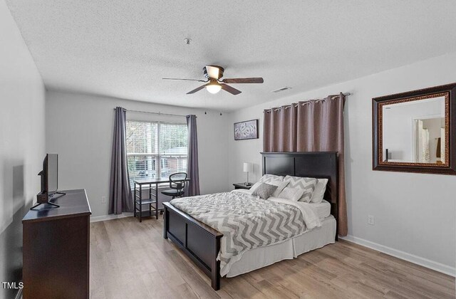 129 Sturbridge Dr Unit 15, Clayton, NC 27520 - bedroom featuring light wood-style flooring, a textured ceiling, baseboards, and a ceiling fan
