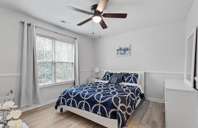 129 Sturbridge Dr Unit 15, Clayton, NC 27520 - bedroom with wood finished floors, baseboards, a ceiling fan, and a textured ceiling