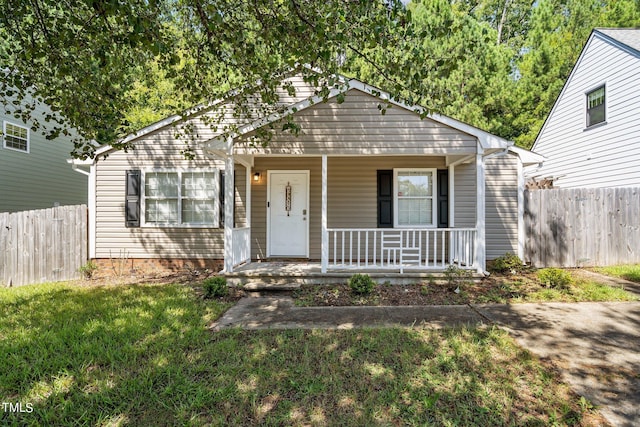 bungalow-style house with a front yard and covered porch