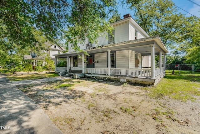 farmhouse inspired home featuring covered porch and a front yard