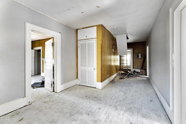 interior space with light hardwood / wood-style flooring and wooden walls