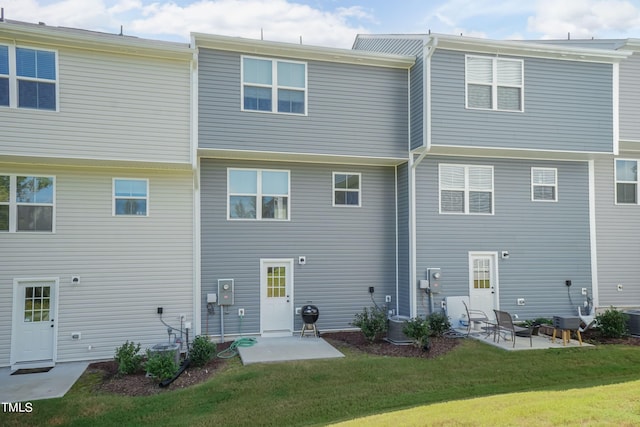 back of house featuring a lawn, a patio area, and central air condition unit