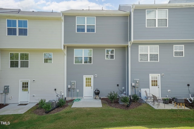 back of house featuring a lawn and a patio