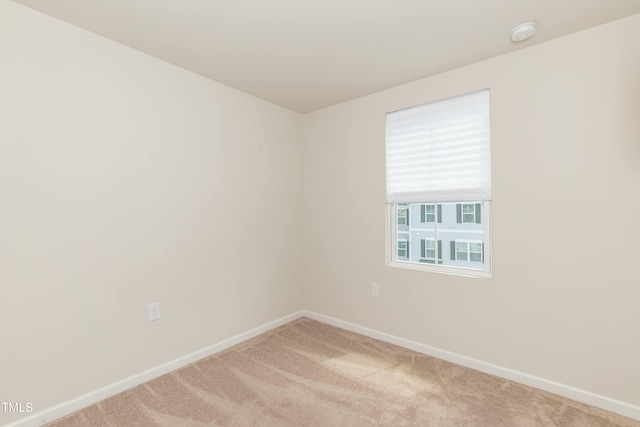 unfurnished room featuring light carpet