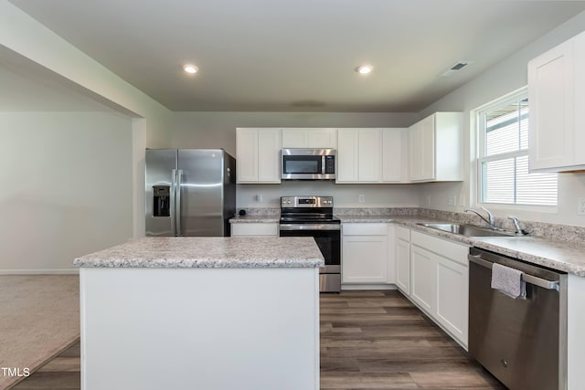 kitchen with a kitchen island, sink, appliances with stainless steel finishes, and dark hardwood / wood-style flooring