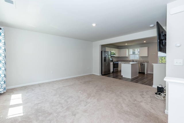 unfurnished living room with wood-type flooring and sink