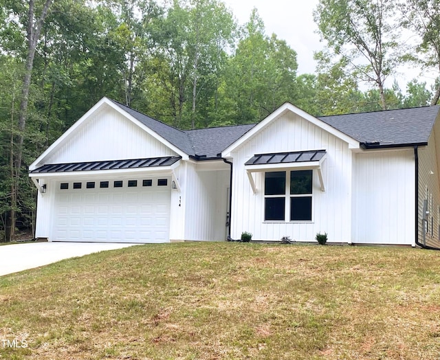 modern farmhouse featuring a garage and a front lawn