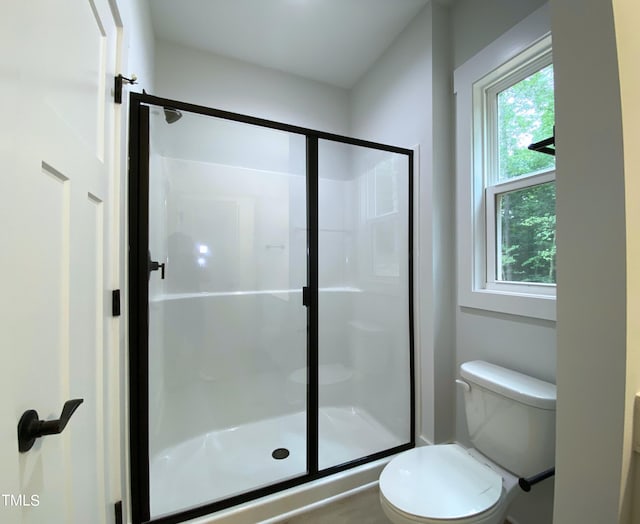 bathroom with an enclosed shower and toilet