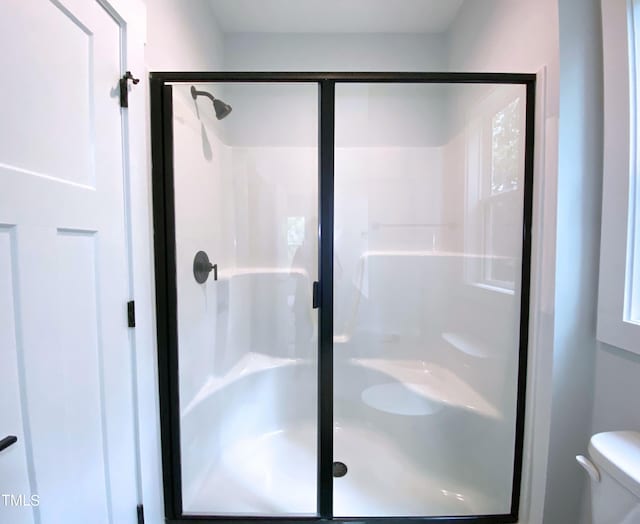 bathroom with walk in shower and toilet