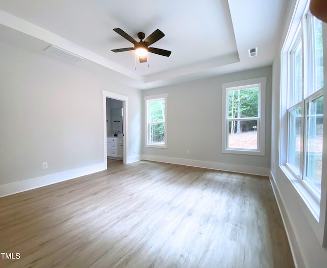 interior space featuring multiple windows, ceiling fan, and light hardwood / wood-style flooring