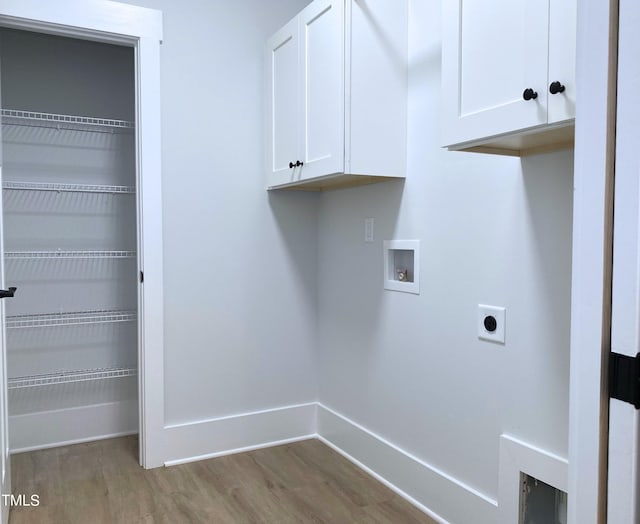 clothes washing area featuring hookup for a washing machine, cabinets, electric dryer hookup, and light hardwood / wood-style flooring