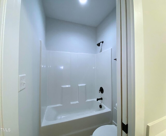 bathroom with bathtub / shower combination and toilet