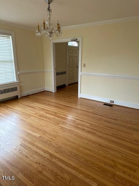 110 S Layton Ave, Dunn, NC 28334 - unfurnished dining area featuring visible vents, ornamental molding, a chandelier, radiator, and light wood-style flooring