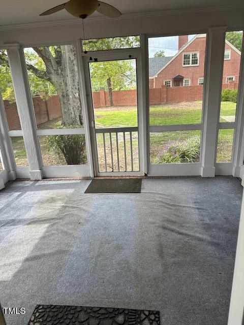 unfurnished sunroom featuring plenty of natural light and ceiling fan