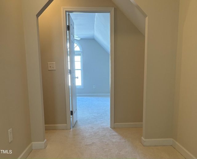 corridor featuring light colored carpet and vaulted ceiling