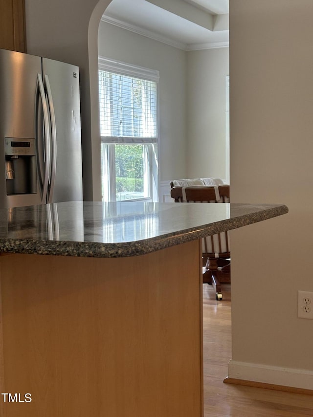 kitchen with light hardwood / wood-style flooring, stainless steel refrigerator with ice dispenser, and ornamental molding