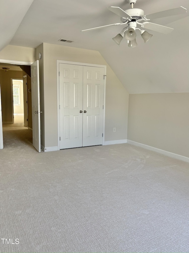 additional living space featuring ceiling fan, light colored carpet, and lofted ceiling