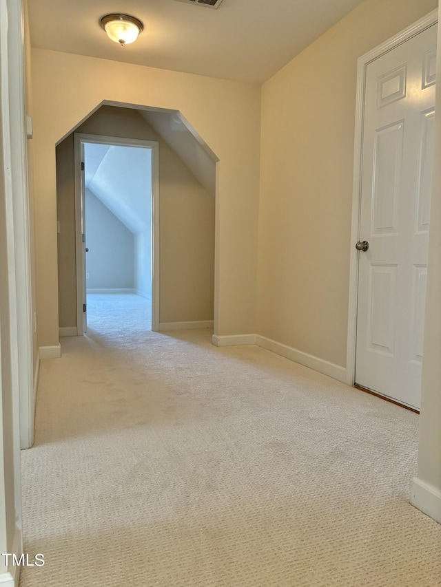 bonus room with light carpet and vaulted ceiling