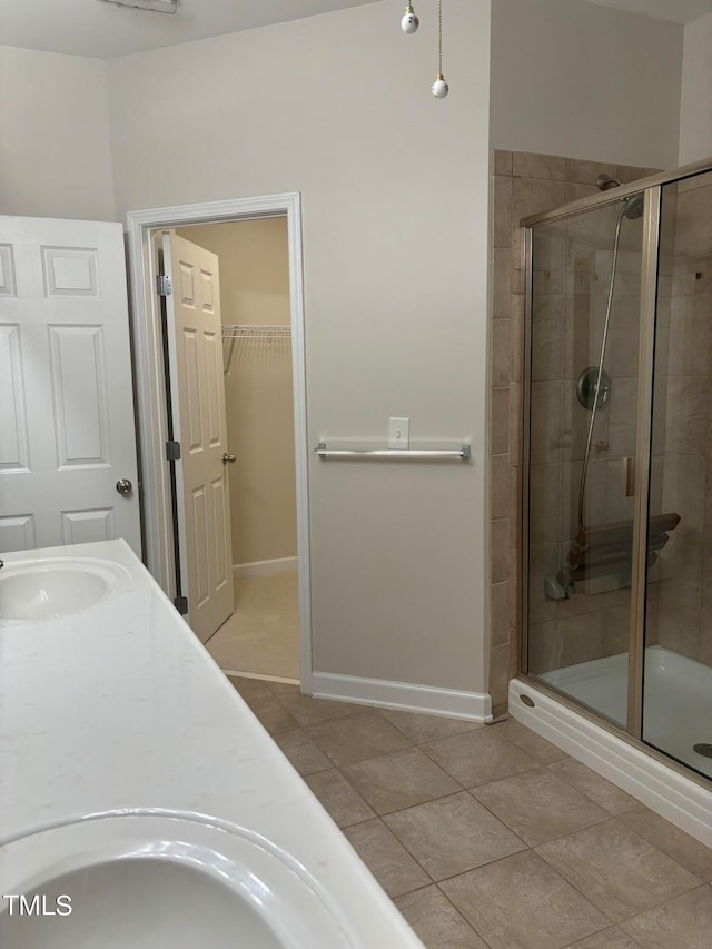 bathroom featuring tile patterned flooring, vanity, and walk in shower