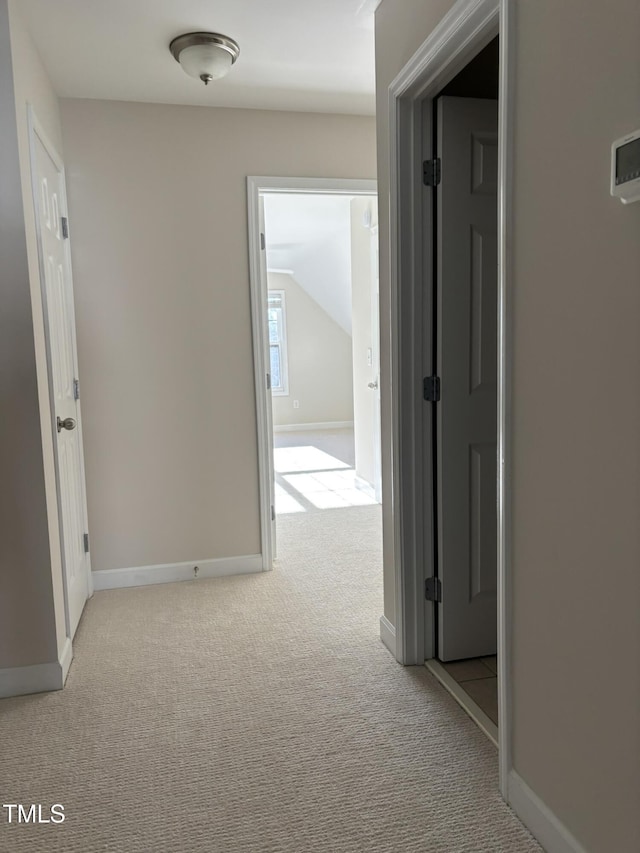 hall with light carpet and lofted ceiling