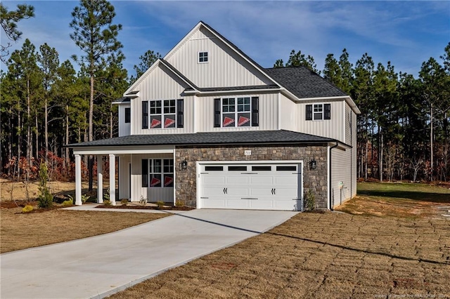 modern farmhouse with covered porch, a garage, and a front lawn