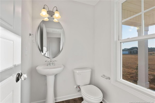 bathroom featuring an inviting chandelier and toilet