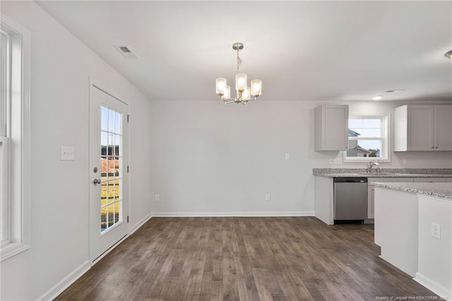 kitchen with decorative light fixtures, dishwasher, sink, dark hardwood / wood-style flooring, and an inviting chandelier