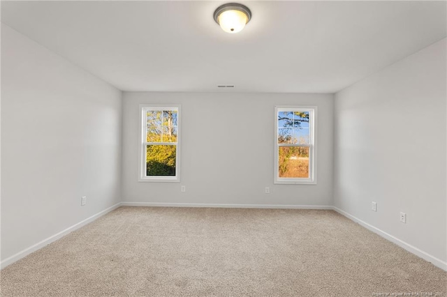 carpeted spare room featuring plenty of natural light