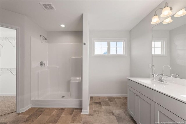 bathroom featuring walk in shower and vanity