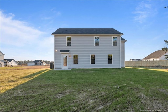 rear view of house featuring a yard